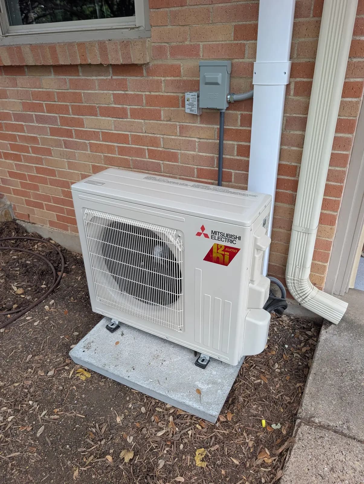 Mitsubishi Electric Hyper-Heat outdoor unit with white line hide against brick