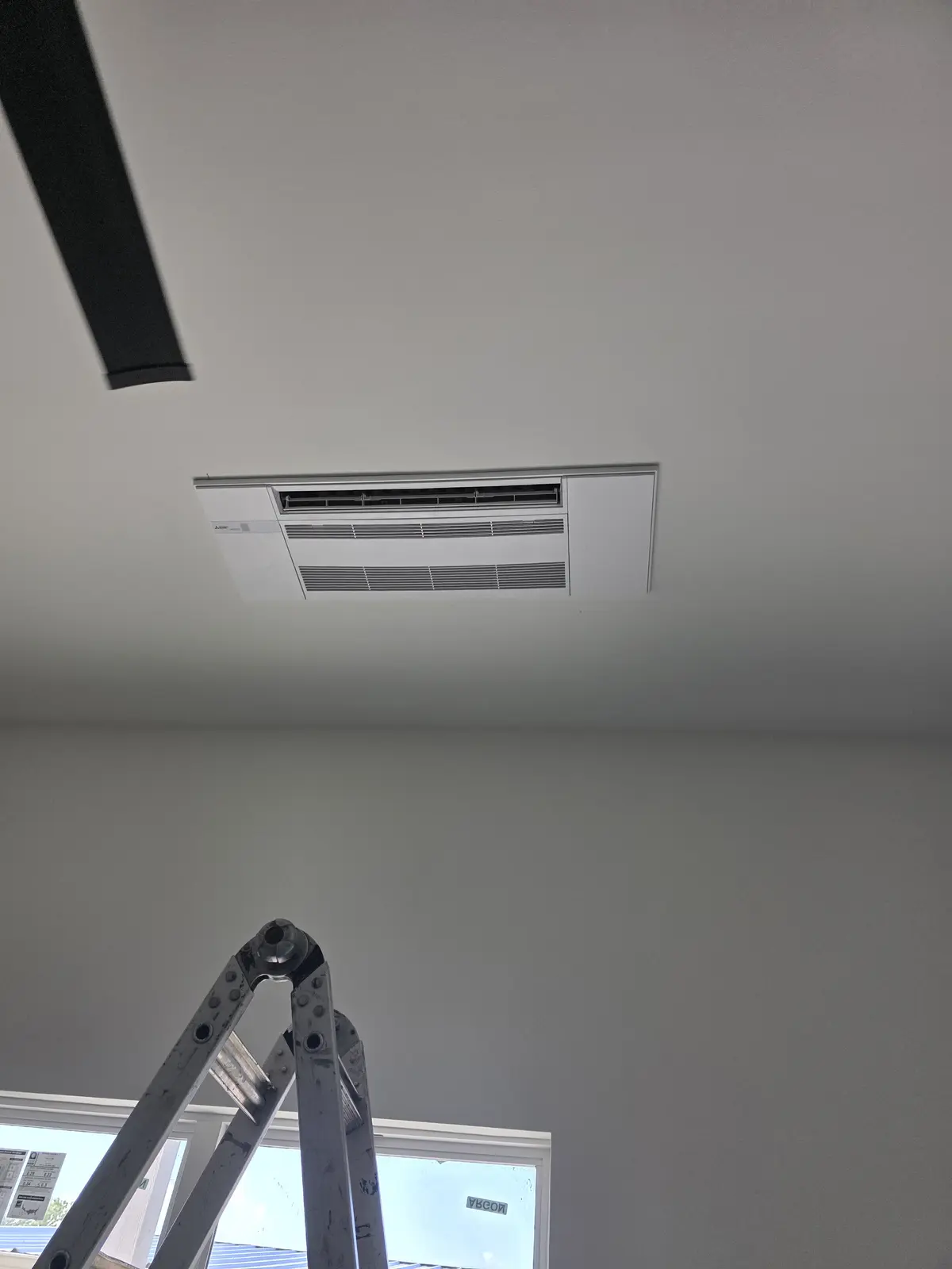 One-way ceiling cassette mini split recessed in a white ceiling