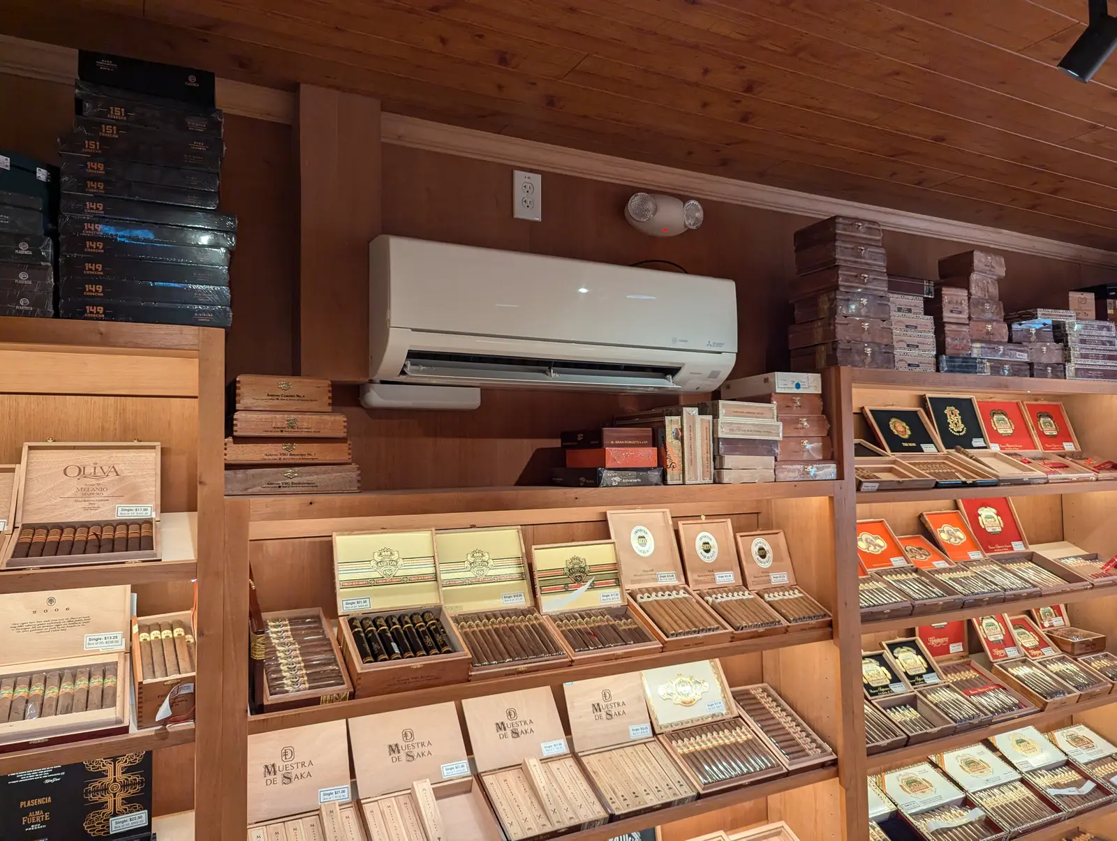 Wall-mount mini split above wood display shelving in a retail humidor room