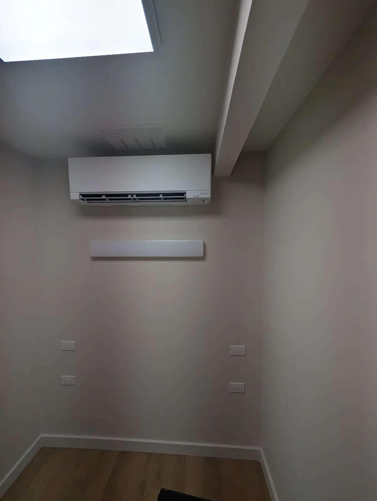 Wall-mount mini split in a small room under a skylight