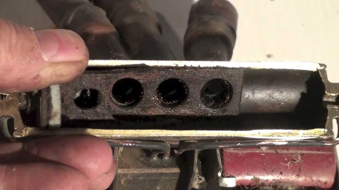 A close-up of a clogged and corroded heat pump valve, highlighting the effects of poor maintenance.