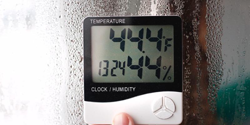 A digital thermometer and hygrometer displaying 44.4°F temperature and 44% humidity against a foggy glass background.