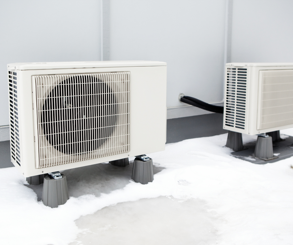 Professional dual heat pump installation featuring white outdoor condensing units properly spaced and elevated above snow level. Demonstrates optimal placement for maximum efficiency and winter operation.