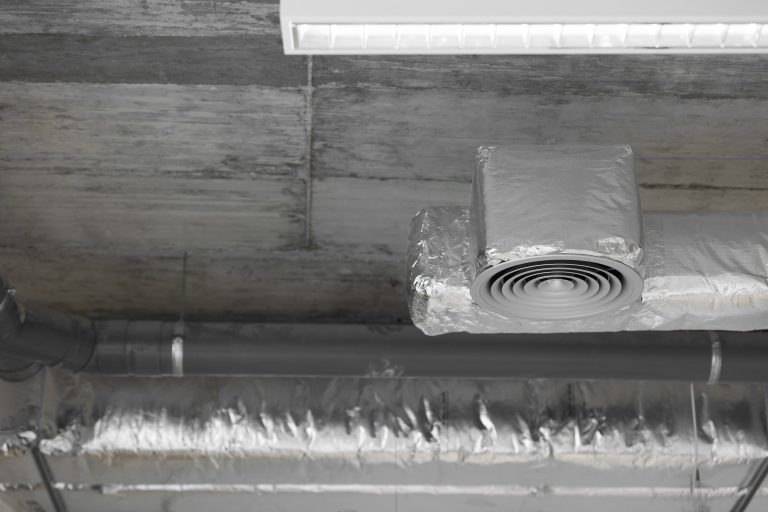 Close-up of a modern ducted mini split system with insulated ducts and a ceiling vent, showcasing efficient ventilation design.